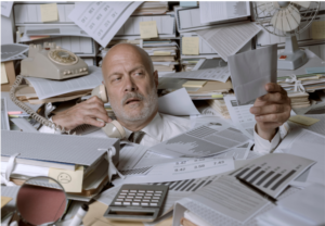 Hombre exhusto viendo facturas físicas por no usar Sistema FEL